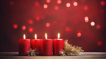 Three red candles on a wooden table with a red background photo