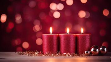 Three red candles on a table with a red background photo