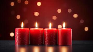 Three red candles on a table with a red background photo