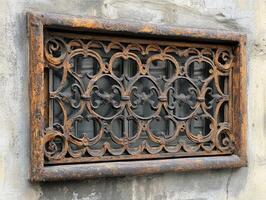 Old rusty metal window grate showing intricate design photo