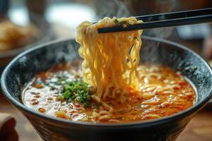Chopsticks lifting noodles from bowl of hot steaming ramen photo