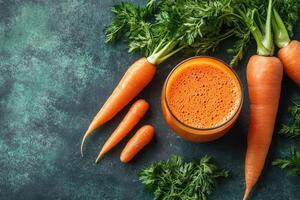 Glass of freshly squeezed carrot juice with carrots on dark background photo
