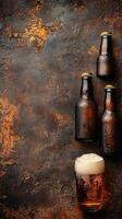 Glass and bottles of beer with foam on grunge background with copy space photo