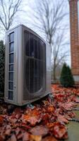 Heat pump standing on wet autumn leaves during fall season photo