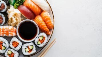 Delicious Sushi Platter with Soy Sauce and Chopsticks on White Background - Perfect for Lunch Breaks and Japanese Cuisine Themes photo