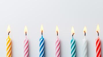 Colorful Party Candles in a Row with Flames Lit Against a White Background for Celebrations and Festivities photo
