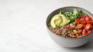 Healthy Quinoa Salad Bowl with Avocado, Spinach, Cherry Tomatoes, and Roasted Vegetables on Light Background photo