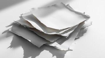 stack of papers with torn jagged edges rests elegantly casting soft shadows on the surface perfect for creative presentations or artistic showcases. photo