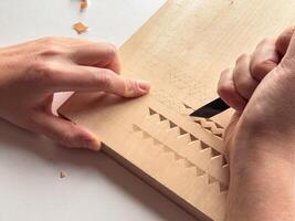 Hand carving intricate geometric patterns on wood with precision and skill photo