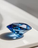 A blue diamond sitting on a white surface photo