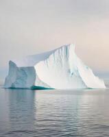 Iceberg in the ocean with a large iceberg floating in the water photo