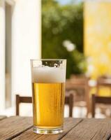 A glass of beer on a wooden table photo