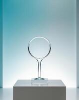 A glass trophy on a pedestal in front of a blue wall photo