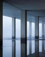 Misty underground parking structure with concrete pillars and water reflections at dawn. photo