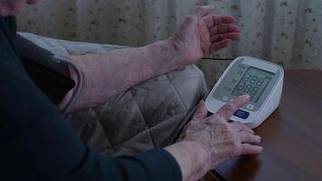 Mature adult taking own vital signs while relaxing on sofa. Empowering self-care and self-sufficiency through accessible at-home technology video
