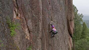 Scaling Nature's Obstacle. A Fearless Adventurer Conquering the Towering Rock Face video