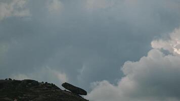 A huge boulder on the edge of the mountain video