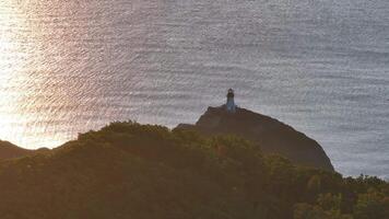 A Majestic Lighthouse Illuminating a Serene Island Amidst the Vast Ocean video