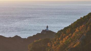 A Majestic Beacon. A Lighthouse Perched Atop a Towering Mountain, Gazing Over the Vast Ocean video