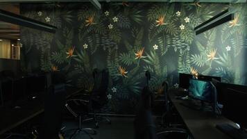 Empty office room after working day with lights off. Stock footage. Modern office with computers and decorative wall. video