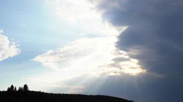 Panorama of cloudy sky with sun and shadow of forest. Media. Overcast clouds with rays of daytime sun on blue sky. Heavenly landscape with shadow of forest video