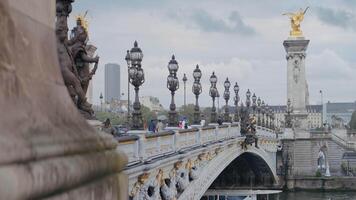 France, Paris - June 28, 2022. Golden statue on ancient bridge. Action. Golden sculpture on pedestal of Paris Bridge. Golden statue on Alexander III Bridge in Paris on cloudy day video