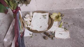 Close up of memorial bouquet of flowers and plate with letter on the ground. Action. Concept of memory and honour. video