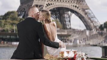 Romantic elegant couple on date at tower. Action. Luxurious elegant couple on date in Paris. Couple on date with view of Eiffel Tower on sunny summer day video