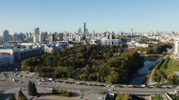 View of the built-up city from a height. Stock footage. A beautiful European city with high-rise buildings and offices and a river is visible over which cars are passing. video