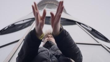 Bottom view of young man dancing with his hands. Action. Stylish young man in jacket dances in modern style. Modern hand dance in urban style video