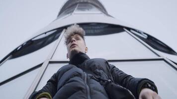 Bottom view of young man dancing with his hands. Action. Stylish young man in jacket dances in modern style. Modern hand dance in urban style video