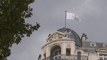 France, Paris - July 29, 2022. Bottom view of old European house with green tree. Action. Exterior of old building with Apple flag in Paris. House on Champs-Elysees with Apple Store video
