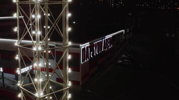 Dark view from the drone on the store. Stock footage. An illuminated shop with bright letters and towers with lanterns. video