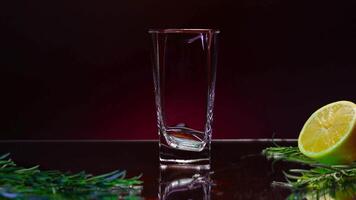 Close up of filling an empty glass with fresh green drink. Stock clip. Details of a bar counter with a half of an orange fruit and rosemary. video