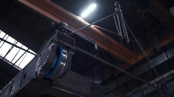 Metal construction on suspensions at factory. Clip. Suspension systems with anchors for carrying loads at factory. Automated movement of heavy structures at factory video
