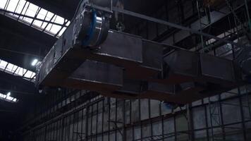Metal construction on suspensions at factory. Clip. Suspension systems with anchors for carrying loads at factory. Automated movement of heavy structures at factory video