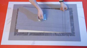 Worker connects tile pattern. Creative. Man connects details of square boards. Man joins pattern of boards and tiles video