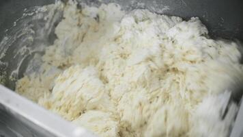 Preparation of dough in industrial machine. Clip. Close up of automatic mixing ingredients for dough with a professional dough mixer. video