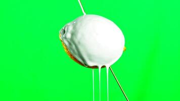 Fresh yellow lemon isolated on a green background. Stock clip. Pouring white paint on a lemon fruit with drops falling down. video