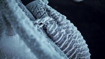 Close-up of wheel frozen in cold. Clip. Close-up of chain and tire hanging frozen on bridge in cold. Frost on abandoned things on frosty winter day video