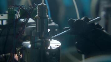 Forceps put substance into equipment. Stock footage. Chemist puts substance into equipment with forceps. Laboratory chemical analyses and experiments with substances video