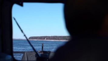 Window in fishing boat with view of river and shore. Clip. View from window of fishing boat on sunny winter day. Window with view of river and shore from boat video