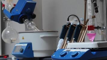 Equipment in chemical laboratory with rotating flasks. Stock footage. Rotating equipment and colored liquid in flask in laboratory. Chemical laboratory analyses with equipment video