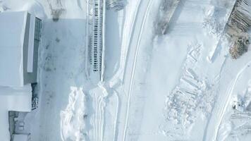 topp se av järnväg med snö. klämma. tömma snötäckt järnväg skenor i vinter. snö faller på solig dag på järnväg video