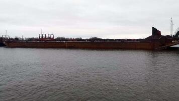 Sea transportation with barges. Clip. Floating barges for cargo transportation on river in winter. Barges on river on cloudy winter day video