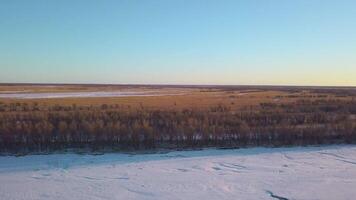 Top view of spring landscape of plains with snow. Clip. Panoramic landscape plain with forest and snow with horizon on sunny day. Forests, meadows and plains with snow on sunny spring day video