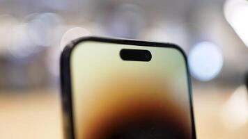 Close-up of phone with camera and glowing screen. Action. Beautiful colorful phone screen and front camera. Modern stylish design of new smartphone video
