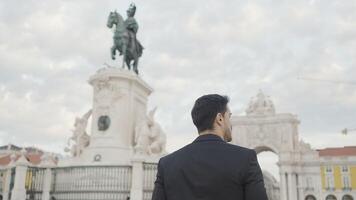 Rear view of joyful middle aged businessman in suit walking outdoors in city square. Action. People and urban background concept. video