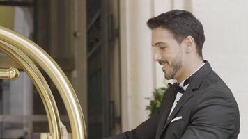 Man in elegant suit with cart. Action. Attractive man in suit with trolley at hotel. Handsome elegant man in suit at expensive hotel video