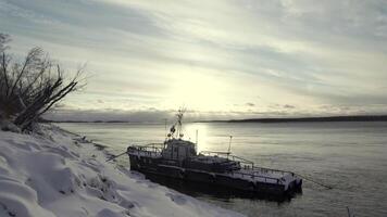 Moored ship covered by snow. Art. Timelapse effect, ship and winter lake on a cloudy sky background. video